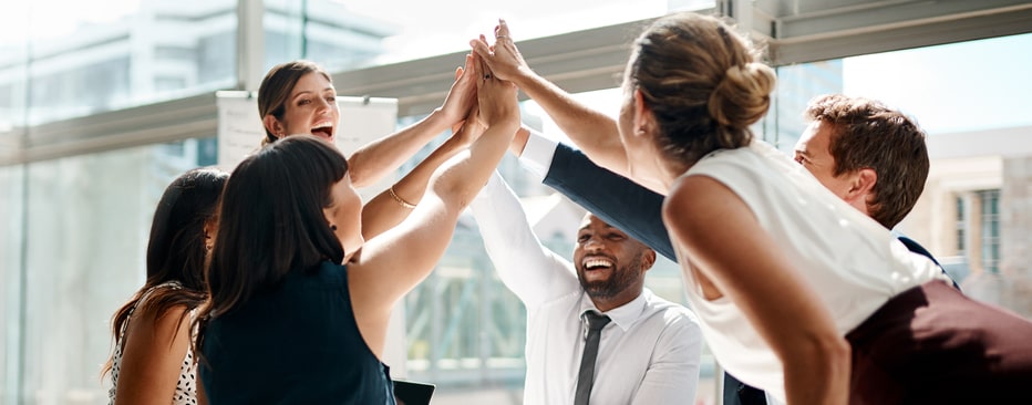 Employee team giving each other high-fives to show teamwork and collaboration 