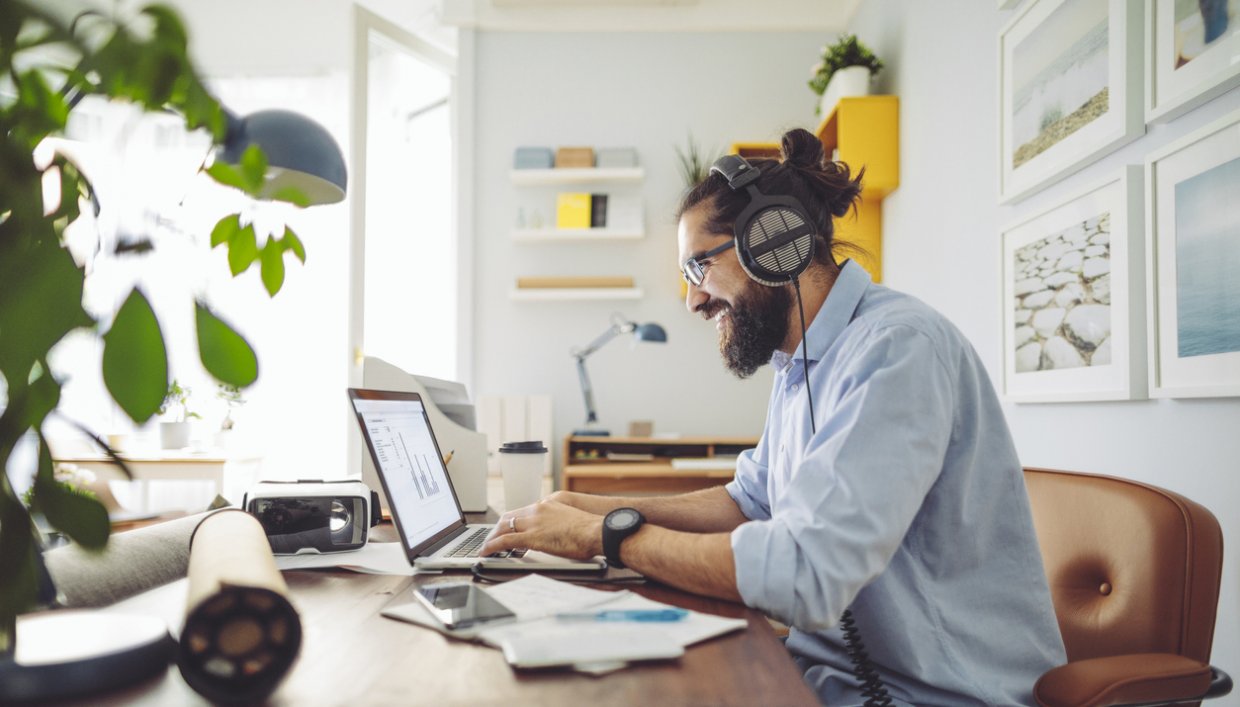 Man working from home on his laptop with headphones