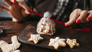 Business owner wrapping holiday cookies for customer appreciation gift