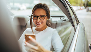 Woman looking at mobile phone in car