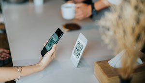 Person holding smartphone showing QR code for payment