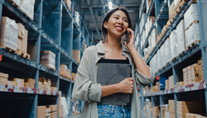 Business employee in warehouse using business mobile