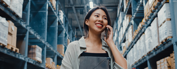 Business employee in warehouse using business mobile