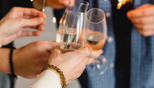 Close-up of hands toasting with champagne glasses