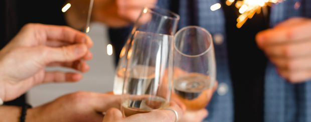 Close-up of hands toasting with champagne glasses